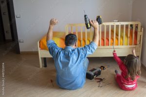 person assembling a baby crib